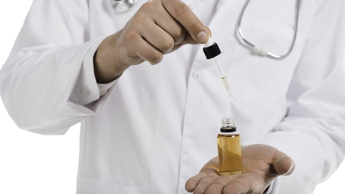 cropped view of male doctor opening up bottle with cbd oil and dropper isolated on white