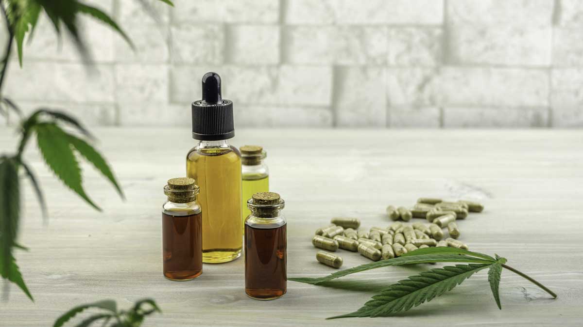 CBD products including soft gel standing together with hemp leaves